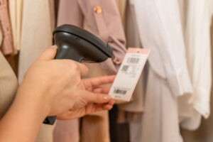 A,Warehouse,Woman,Employee,Accepts,Clothes,Using,Barcode,Scanner,Reading